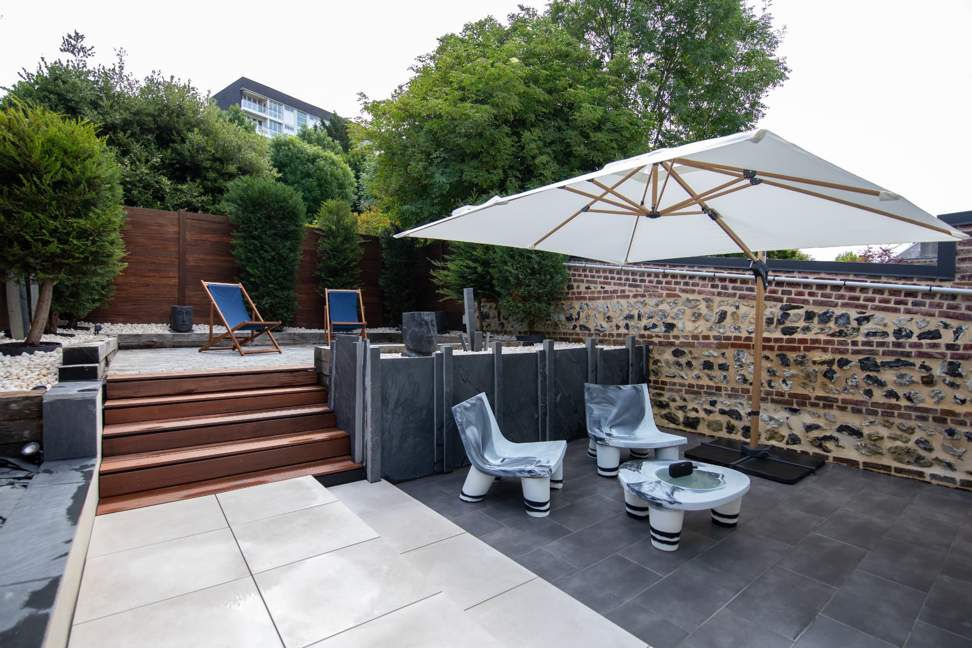 Terrasse et jardin privatifs de L'Échappée, transats et végétation