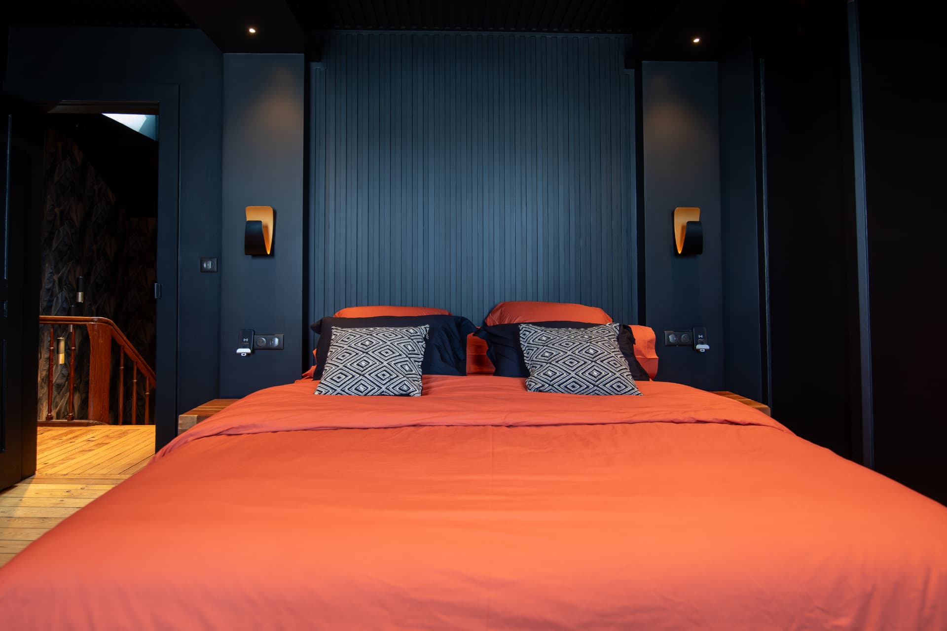 Espace nuit avec lit 180 × 200 cm, tête de lit en tasseaux et linge terracotta