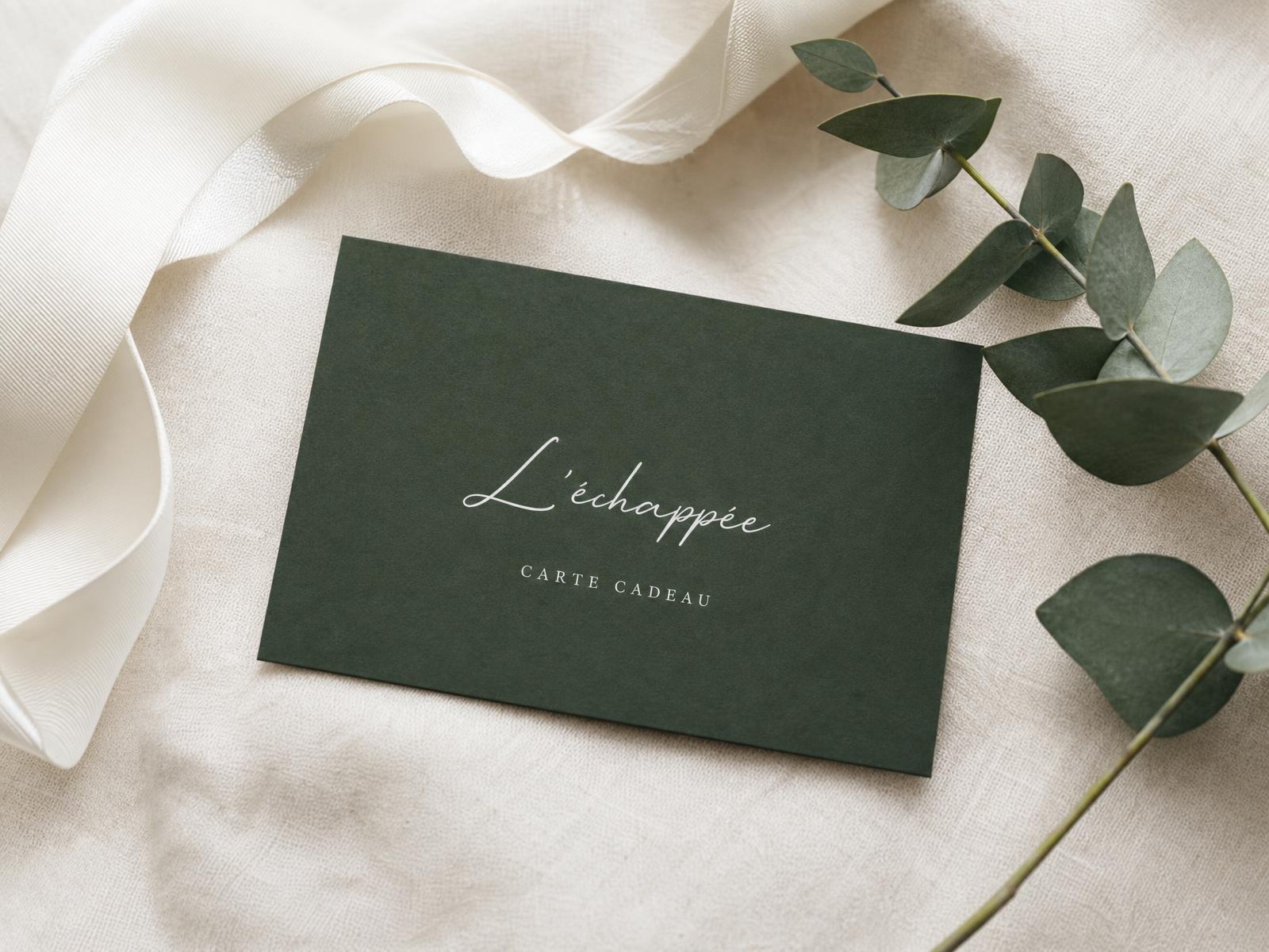 Carte cadeau L'Échappée posée sur un lin ivoire
